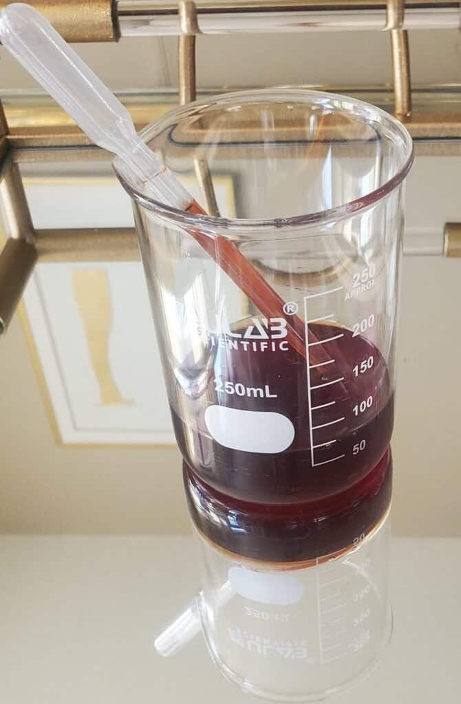 Shikakai extract concentrate in glass beaker - DIY natural ingredient preparation for conditioning dandruff treatment