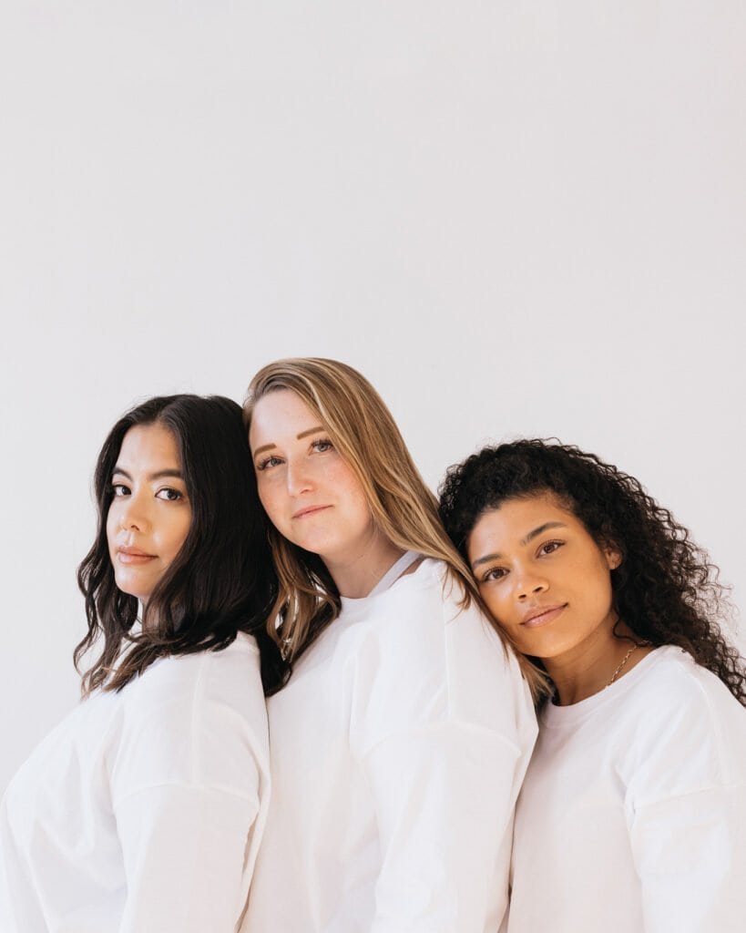 Three women with diverse hair types showing healthy, dandruff-free hair after successful natural scalp treatment