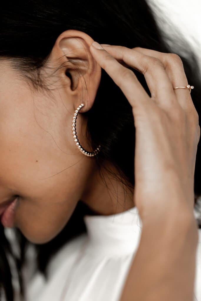 Woman with healthy dark hair touching scalp area, illustrating scalp health examination and care