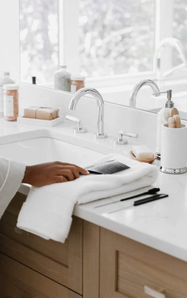 Modern bathroom counter with comb and hair products, demonstrating scalp care routine preparation