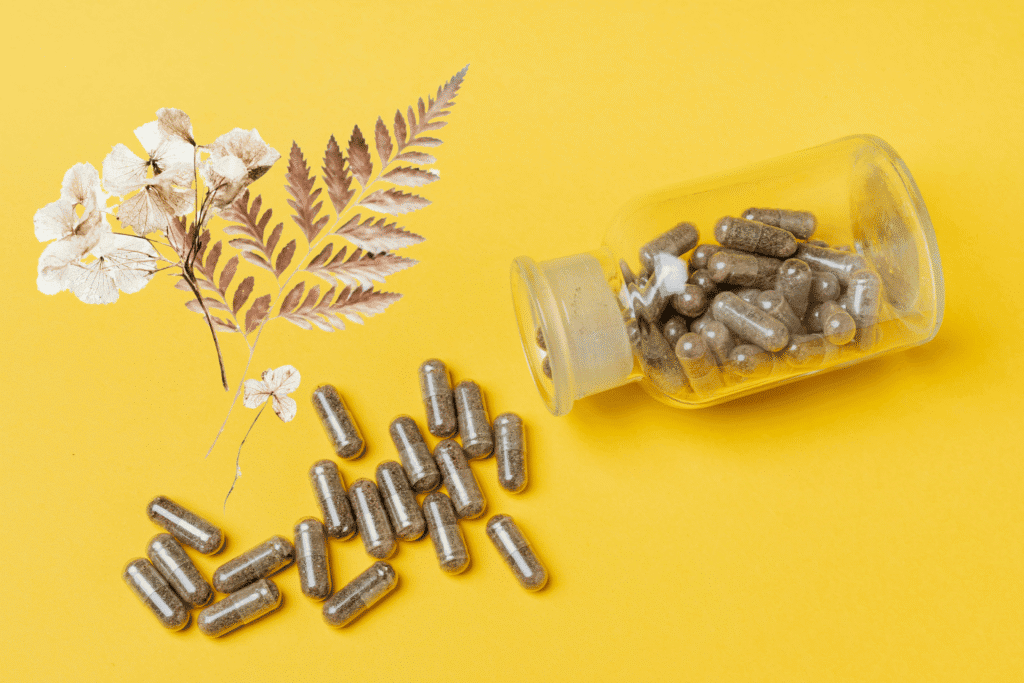 Polypodium leucotomos supplement capsules with fern leaves on yellow background for sun protection