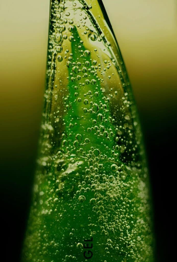 Extreme close-up of a translucent aloe vera gel leaf with water bubbles, representing the soothing anti-inflammatory and antimicrobial properties of aloe vera for acne-prone skin