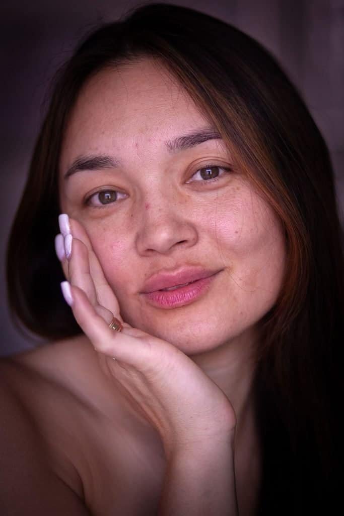 Close-up of a woman's face showing visible skin texture and mild blemishes